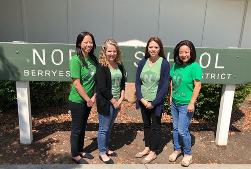 Four second grade teachers standing in front of the Noble School sign